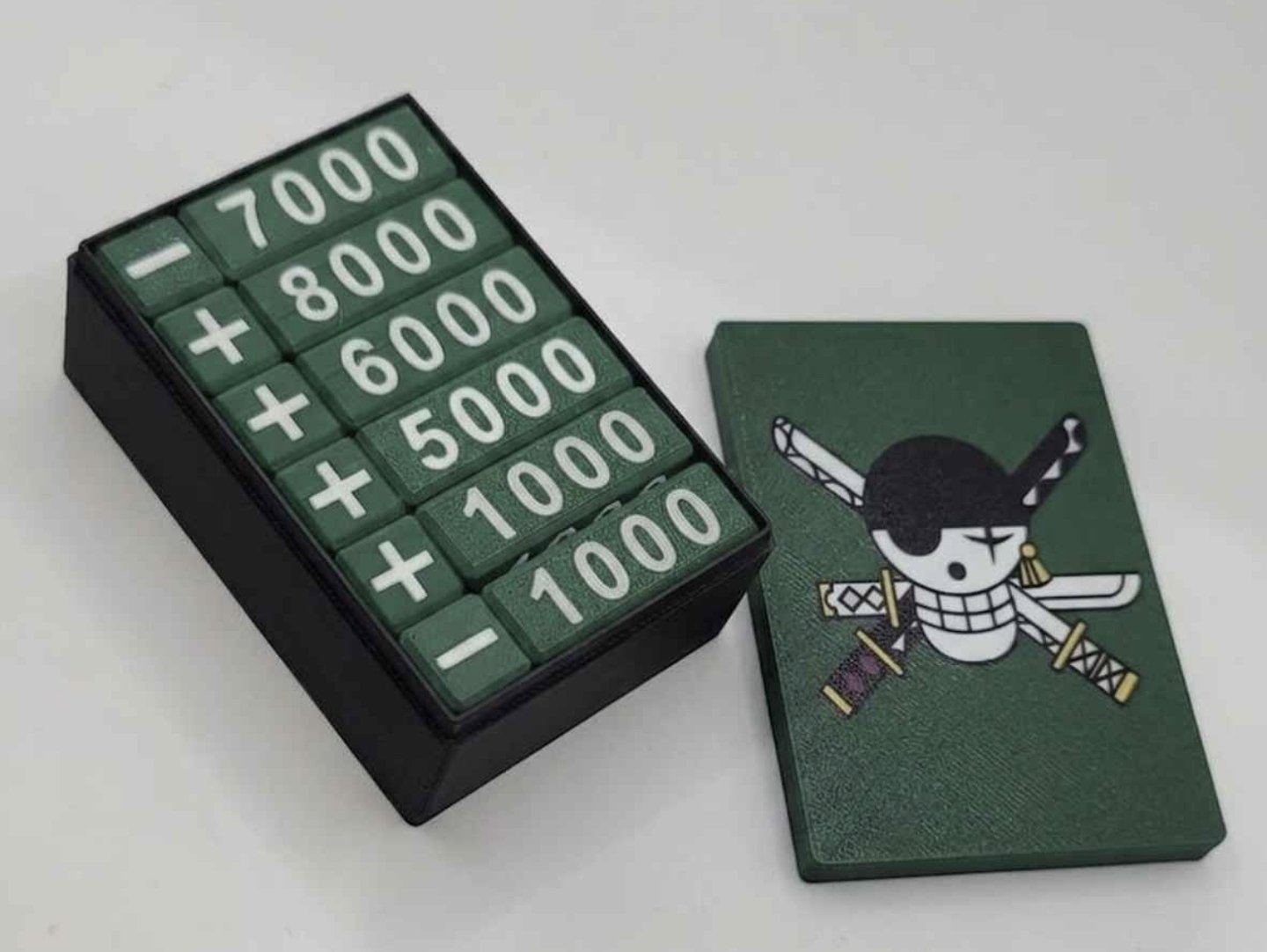 Green One Piece damage counters in a black box with a green Zoro skull lid