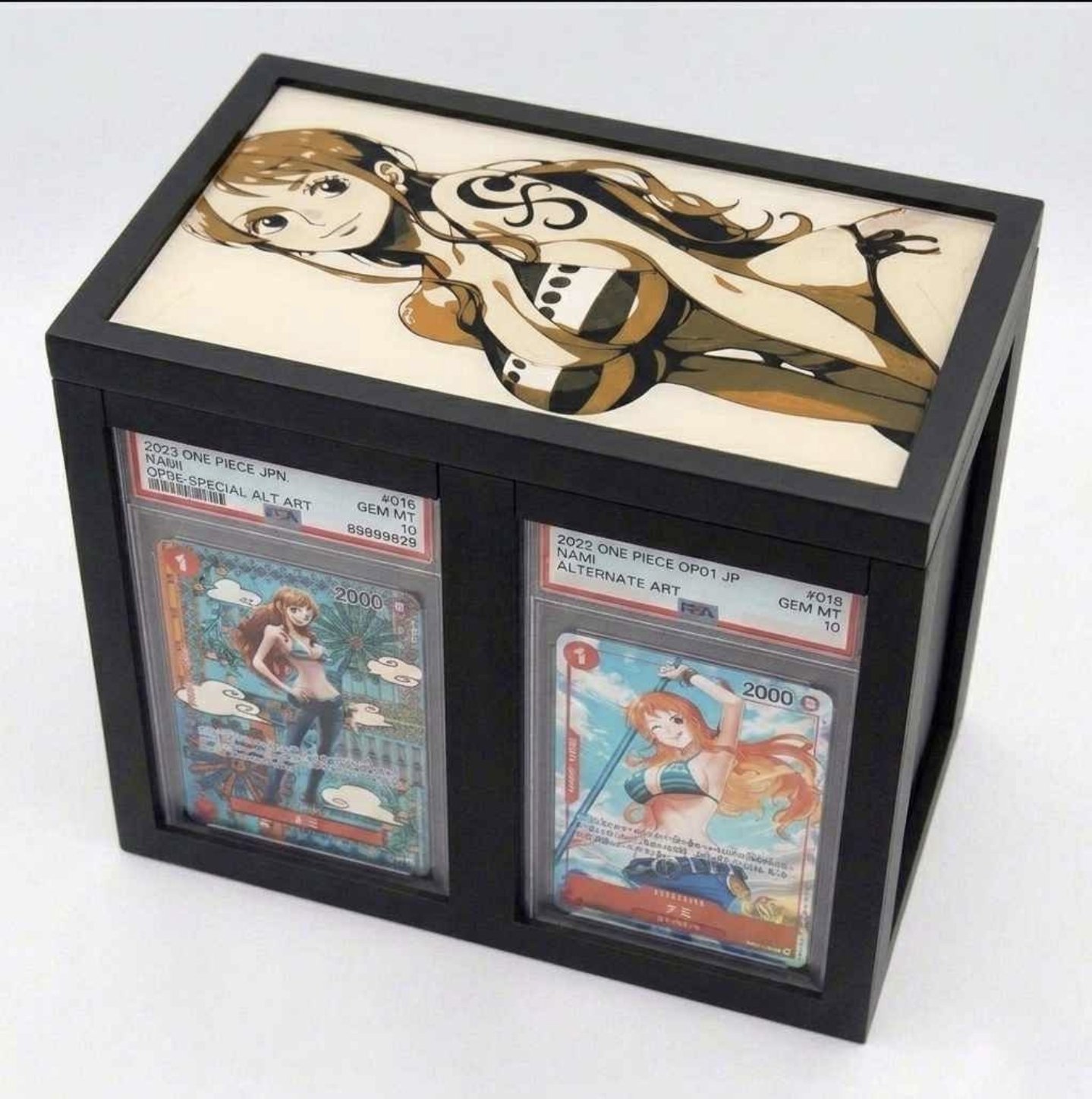Black Slab Stations display with Nami artwork holding two PSA-graded One Piece cards