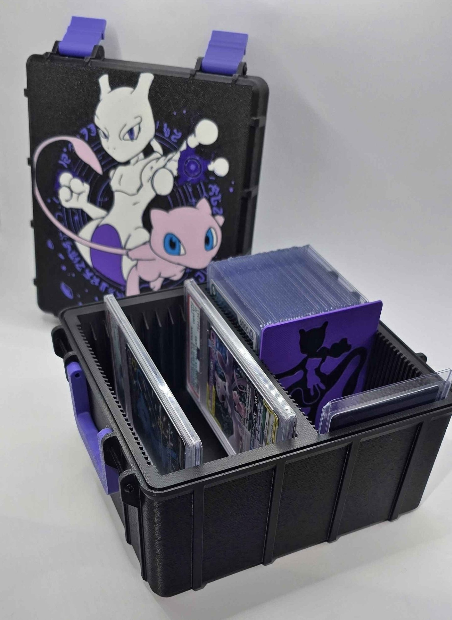 Open black custom card case holding cards with Mewtwo and Mew artwork on the lid